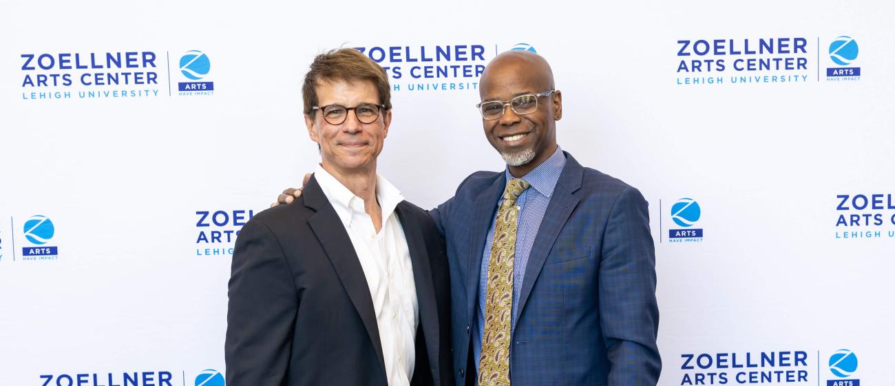 Marc Falato ’87 standing next to Mark Wilson in front of a Zoellner Arts Center backdrop banner.
